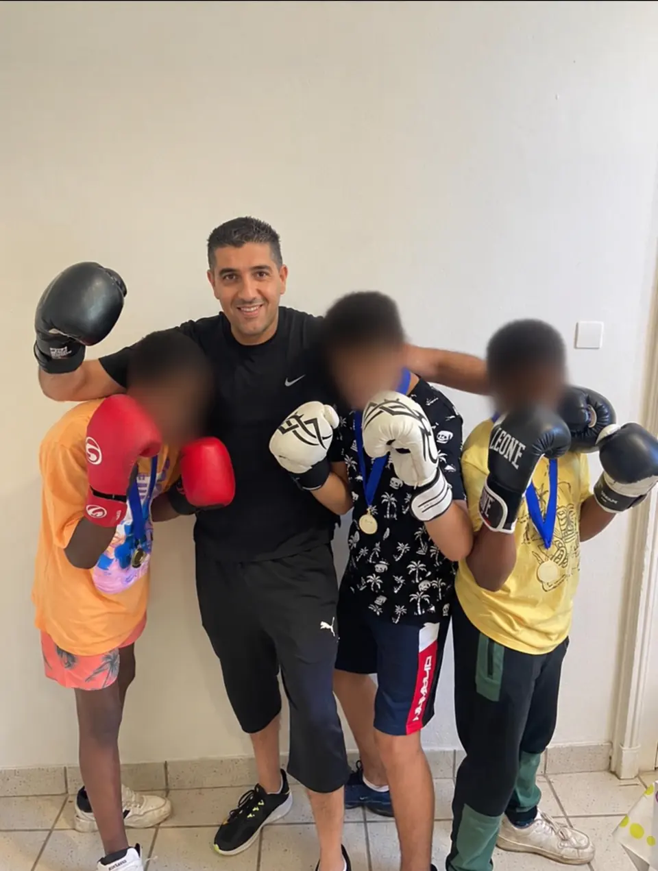 Kamel avec trois jeunes participants aux visages floutés