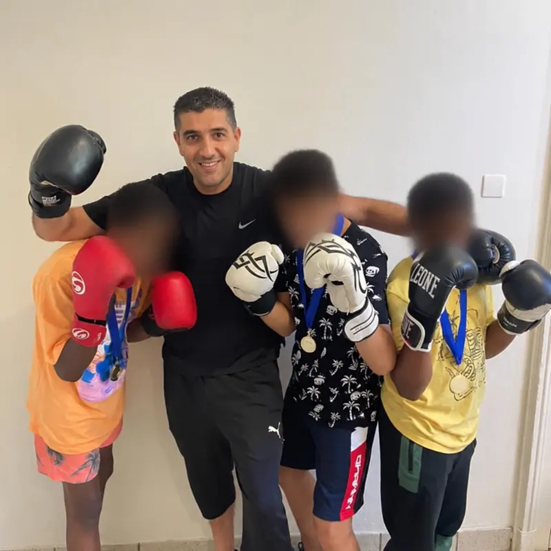 Kamel avec trois jeunes participants aux visages floutés