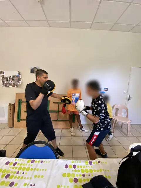 Kamel accompagne un exercice ; les autres visages sont floutés
